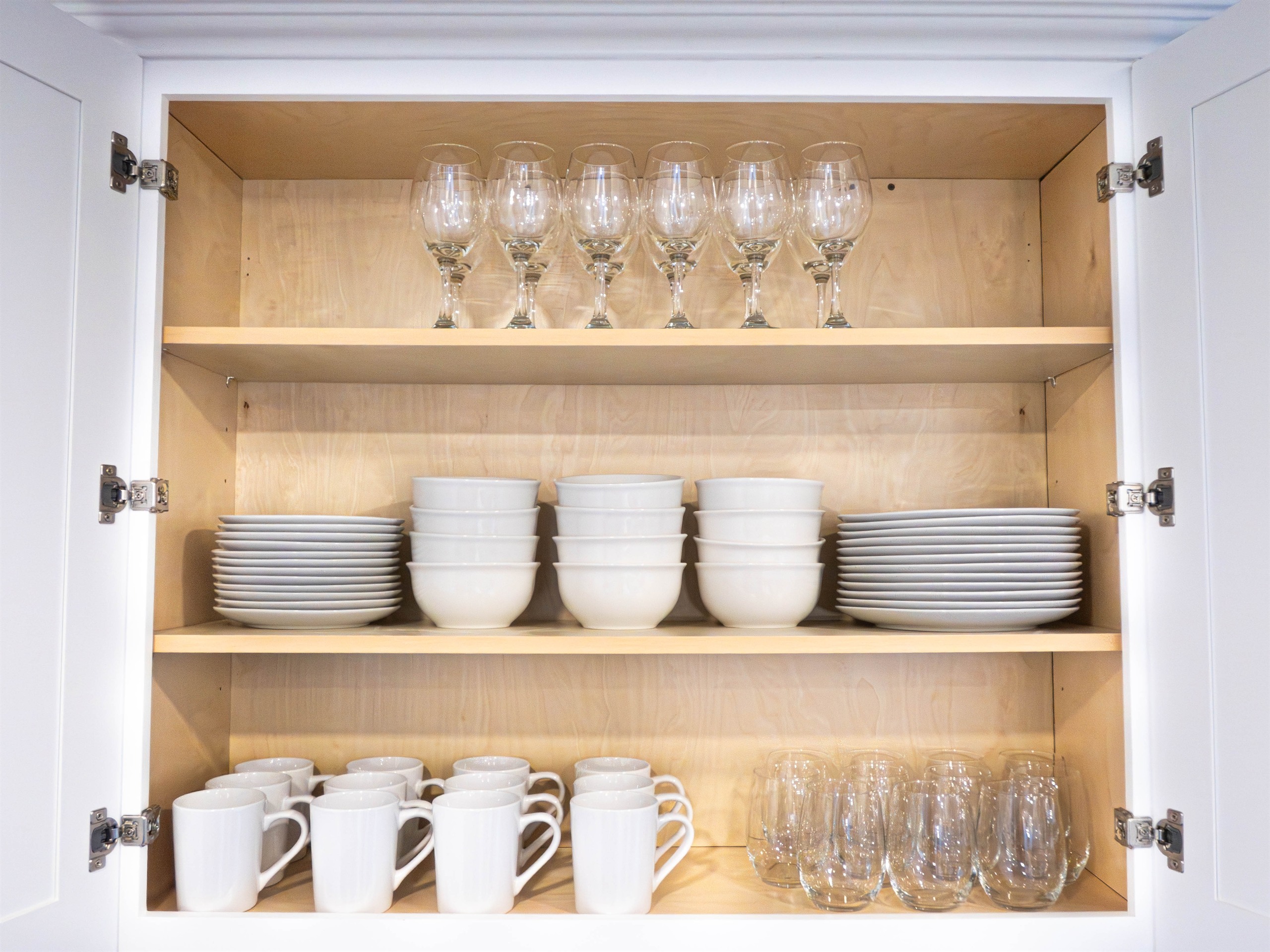 Stocked glassware cabinet showing daily-living readiness